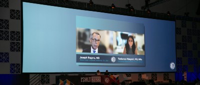 A large screen featuring two pre-recorded speakers