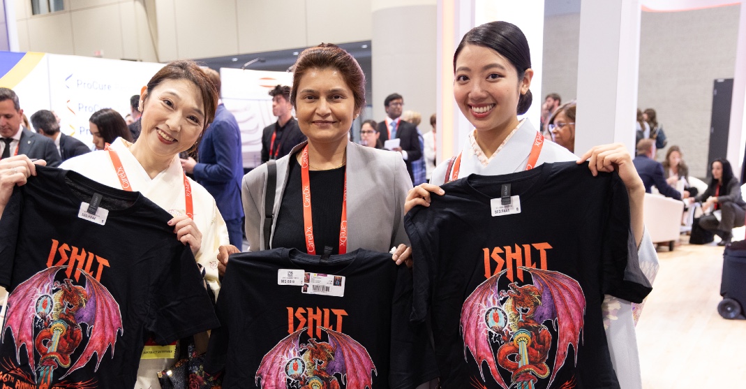 Three women holding up their ISHLT2027 shirts