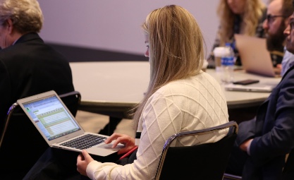 Woman in a white sweater working on her computer