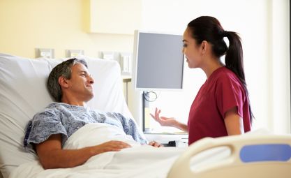 Photo of nurse speaking to a patient in a hospital bed