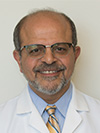 Man with black glasses wearing a light blue shirt and white lab coat