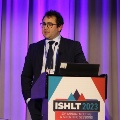 Photo of a man standing at a podium at ISHLT2023