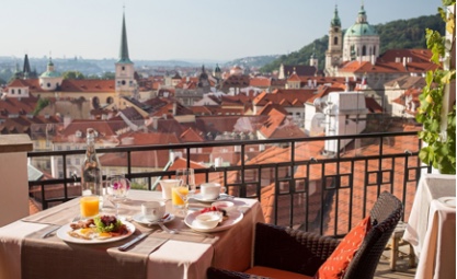 Photo of outdoor table with food and a view of prague