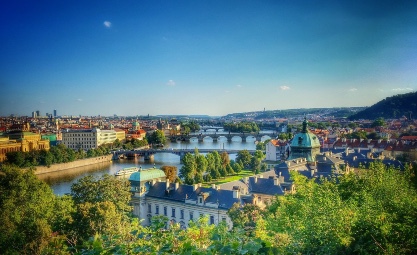Photo of Prague River with trees and green leaves.