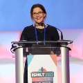 Photo of woman at a podium presenting at ISHLT2023