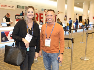 Photo of two people standing in front of the registration area at ISHLT2023