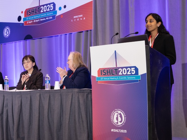 Photo of an early career presenter standing at the podium at ISHLT2025