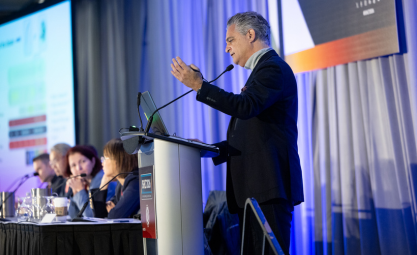 Man with grey hair stands at a podium at ISHLT2026