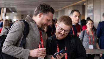 Two men looking at phones and smiling