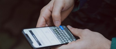 A pair of hands holding a mobile phone